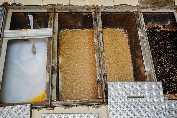 foul odors, slow drainage, and grease buildup are all indicators that grease trap maintenance is needed